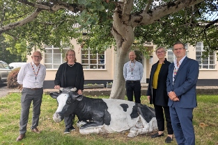 Staff members stood outside next to the model cow at Langford